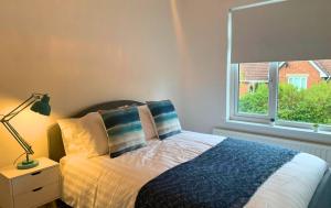 a bedroom with a bed and a window at Shotley Bridge - Stunning 2 bedroom apartment in Consett