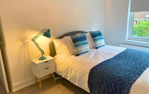 a bedroom with a bed and a lamp on a night stand at Shotley Bridge - Stunning 2 bedroom apartment in Consett