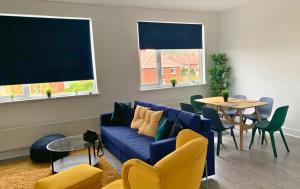 a living room with a blue couch and a table at Shotley Bridge - Stunning 2 bedroom apartment in Consett