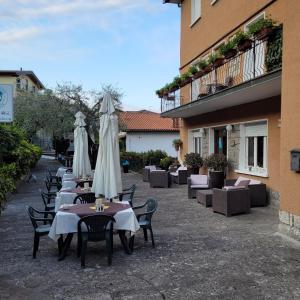 a row of tables with white umbrellas on a patio at Hotel Bellavista Meublè in Monte Isola