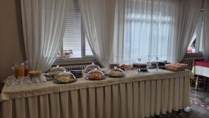 una mesa con platos de comida y vasos. en Hotel Bellavista Meublè en Monte Isola