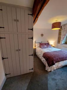 a bedroom with a bed in a room with cabinets at Old Town Hall Holiday Cottage in Hebden Bridge