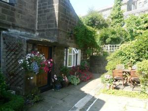 a garden with a table and benches and flowers at Old Town Hall Holiday Cottage in Hebden Bridge
