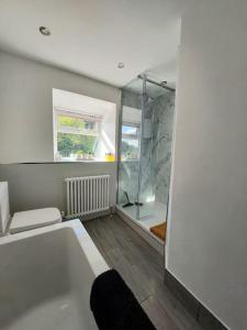 a bathroom with a bath tub and a shower at Old Town Hall Holiday Cottage in Hebden Bridge