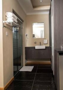 a bathroom with a sink and a shower and a mirror at Charchoma Restaurant in Mombasa