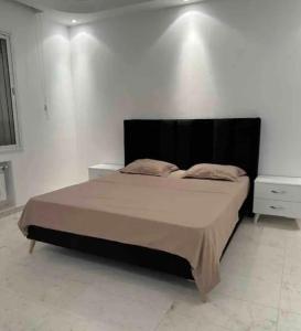 ein Schlafzimmer mit einem großen Bett und einer weißen Wand in der Unterkunft Appartement haut standing 170 m2 in Tunis