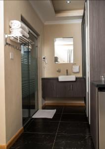 a bathroom with a sink and a mirror at Charchoma Restaurant in Mombasa