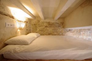 a bed in a room with a stone wall at 209 Livingtarifa Catamaran in Tarifa