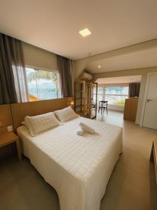 1 dormitorio con 1 cama blanca grande en una habitación en Hotel Pousada 7 Mares, en Itapema