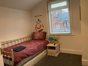 uma pequena cama num quarto com uma janela em 3 bedroom Victorian house close to City centre em Exeter