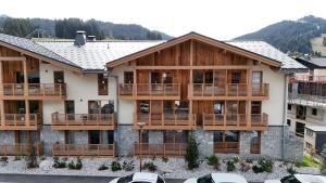 um edifício de apartamentos com varandas em madeira e uma montanha em STELLA - Les Gets - Centre village em Les Gets