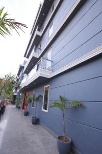 a blue building with potted plants in front of it at Hotel Wedlock sector 47 in Gurgaon