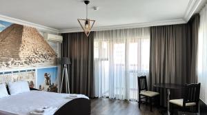 ein Schlafzimmer mit einem großen Bett und einem Tisch in der Unterkunft Meatsa Hotel in Kardschali
