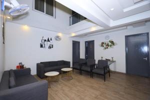 een woonkamer met een bank, stoelen en een tafel bij Hotel Wedlock sector 47 in Gurgaon
