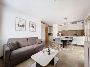 een woonkamer met een bank en een tafel bij AMBRE BLANCHE A106 - Les Gets - Centre village in Les Gets