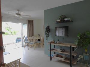 a living room with a television and a table with chairs at Golden View Apartment in Saint James