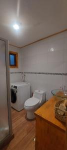 a bathroom with a toilet and a sink at casa de campo in Villarrica