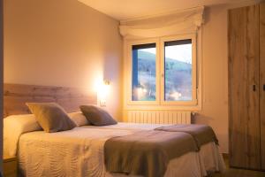 1 dormitorio con cama y ventana en Apartamentos Alto Ubiro en Liérganes