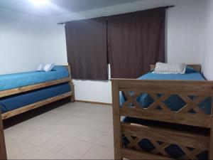 1 dormitorio con 2 camas y ventana en El Molino cabañas en General Juan Madariaga