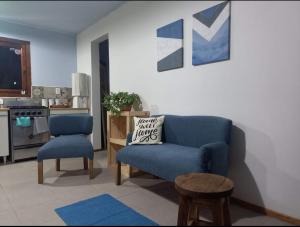 sala de estar con sofá azul y silla en El Molino cabañas en General Juan Madariaga