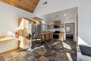 a kitchen with a stainless steel refrigerator and wooden cabinets at Tranquil Pine Mountain Retreat cabin in Pine Mountain Club