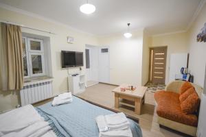 ein Zimmer mit einem Bett, einer Couch und einem Fernseher in der Unterkunft Eleven - 11 in Yeghegnadzor