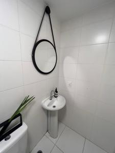 a white bathroom with a sink and a mirror at Confortavel apartamento em SP in Sao Paulo