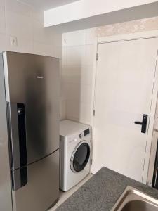a kitchen with a refrigerator and a washing machine at Confortavel apartamento em SP in Sao Paulo