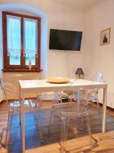een eetkamer met een tafel met stoelen en een televisie bij 2 bedrooms apartement with city view balcony and wifi at Carisolo in Carisolo