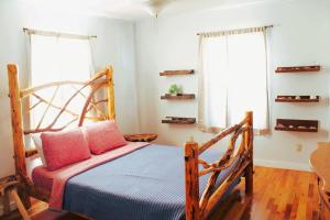 a bedroom with a wooden bed and two windows at Mountain View Get Away in Mountain View