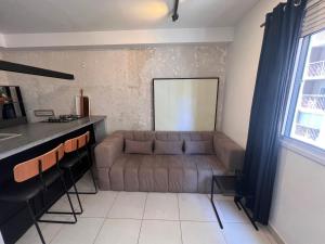 ein Wohnzimmer mit einem Sofa und einem Fenster in der Unterkunft Confortavel apartamento em SP in São Paulo
