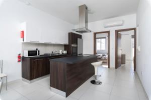 a kitchen with a black counter top in a room at Spacious & Stylish 3BR Penthouse With Large Terrace - Close to Spinola Bay in St Julian's