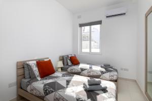 a living room with a bed and a couch at Spacious & Stylish 3BR Penthouse With Large Terrace - Close to Spinola Bay in St Julian's