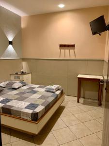 Un pat sau paturi într-o cameră la Hotel Glória