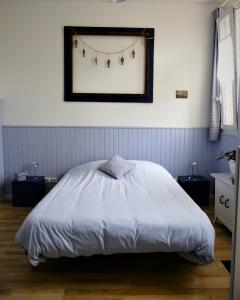a bedroom with a white bed with lights on the wall at Pony Sweet Home in Caen