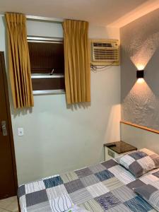 Schlafzimmer mit einem Bett und einem Fenster in der Unterkunft Hotel Glória in Niterói