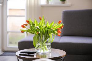 um vaso de flores numa mesa numa sala de estar em Stadtoase am Doberaner Platz New6Pers em Rostock