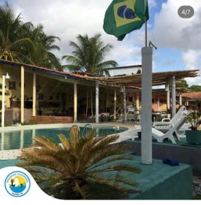 a flag on a pole next to a swimming pool at Pousada Cuiarana Salinas in Salinópolis