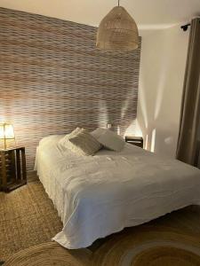 Un dormitorio con una cama blanca con una ventana grande. en Maison confortable à Jard-sur-Mer avec grand jardin clôturé, en Jard-sur-Mer