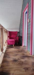 a living room with a pink couch on a wooden floor at Ostoja Karkonoska in Podgórzyn