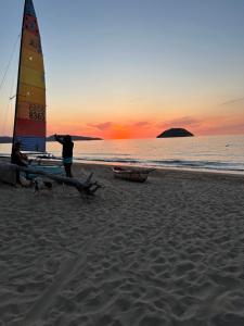 uma pessoa de pé em uma praia com um veleiro em Casa Moka em Peñita de Jaltemba