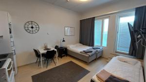 sala de estar con 1 cama, 1 mesa y 1 habitación en Kotimaailma Apartments Vapaudenkatu 48-50 B51 en Jyväskylä