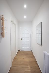 pasillo con puerta blanca y suelo de madera en Effedi Loft, en Barletta