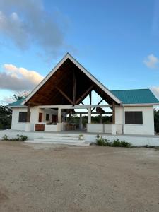 a large white building with a green roof at Belizima Eco Resort in Sarteneja