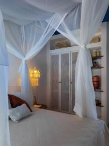 Un dormitorio con una cama blanca con cortinas. en Beachfront 7-bedroom Villa in Taiba - Kitesurfing Paradise en São Gonçalo do Amarante