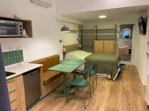 ビセンテ・ロペスにあるCASA MARU - La Verdeのベッド、テーブル、椅子が備わる客室です。