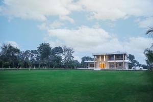 a house with a large green field in front of it at FILLOW CASA in Gurgaon