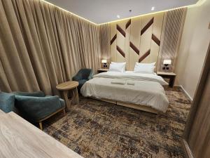 um quarto de hotel com uma cama e duas cadeiras em SEAGULL HOTEl em Umm Lajj