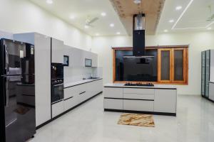 a kitchen with black appliances and white cabinets at FILLOW CASA in Gurgaon