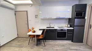eine Küche mit schwarzen und weißen Geräten und einem Tisch in der Unterkunft FlatG 23 in Athen